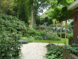 Hoektuin Naarden gemengde border met gazon en pergola